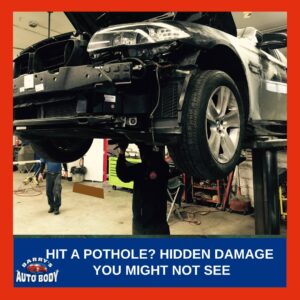 Close-up of a vehicle tire and technician inspecting the suspension system after hitting a pothole